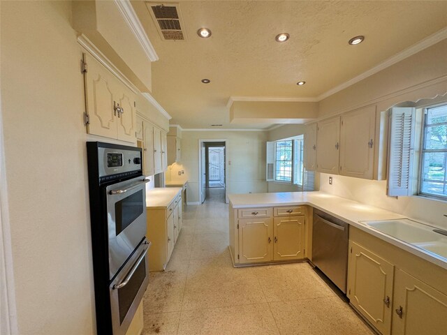 kitchen with kitchen peninsula, ornamental molding, sink, and stainless steel appliances