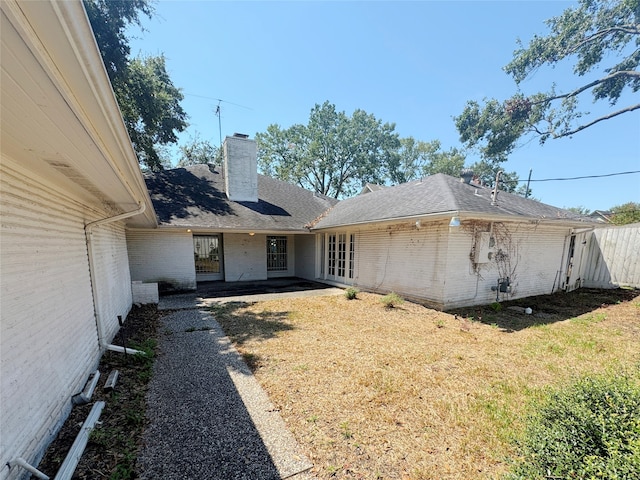 rear view of property featuring a patio area and a yard