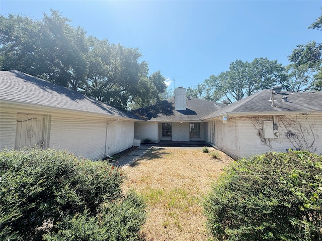 rear view of house featuring a lawn