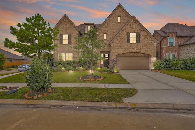 english style home with a garage and a yard