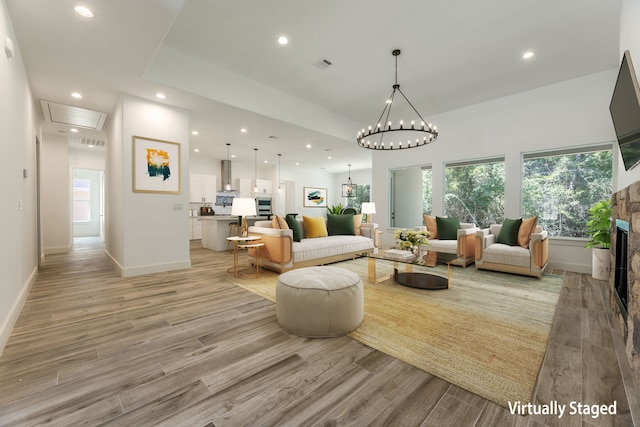 living room featuring a chandelier and a fireplace