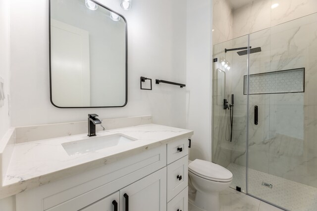 bathroom featuring vanity, an enclosed shower, and toilet