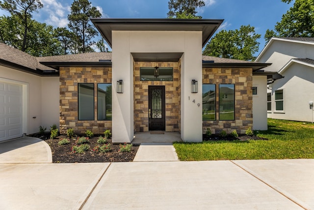 entrance to property with a garage and a lawn