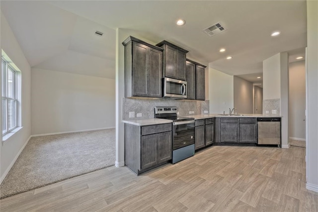 kitchen with backsplash, stainless steel appliances, dark brown cabinetry, and light hardwood / wood-style floors