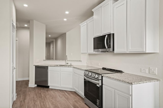 kitchen featuring stainless steel appliances, light stone countertops, sink, and white cabinets