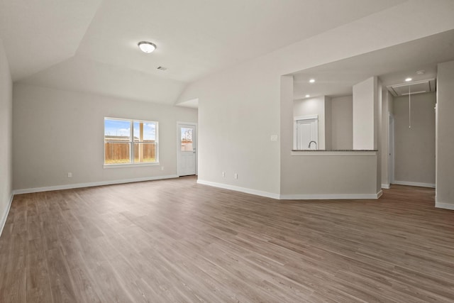 unfurnished room featuring hardwood / wood-style flooring and vaulted ceiling