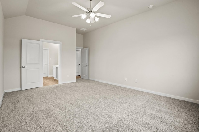 unfurnished bedroom featuring lofted ceiling, light carpet, ceiling fan, and ensuite bath