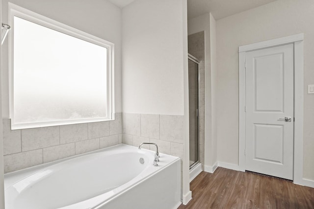 bathroom featuring hardwood / wood-style flooring and shower with separate bathtub