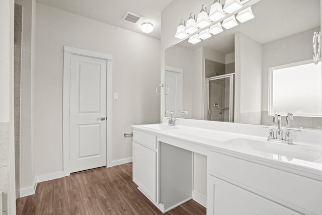 bathroom with an enclosed shower, wood-type flooring, and vanity