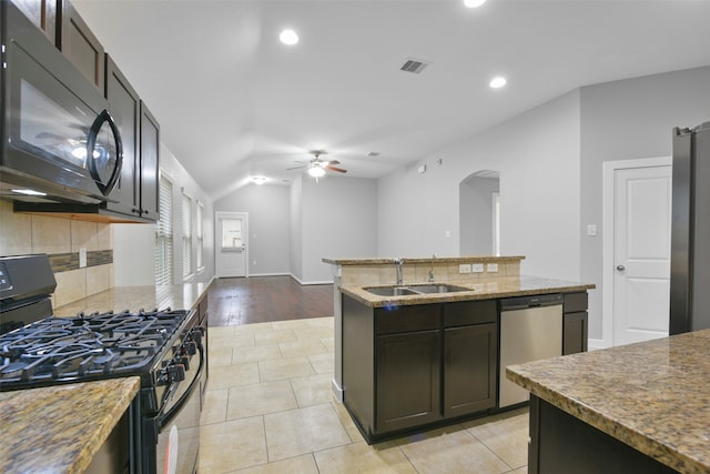 kitchen featuring light hardwood / wood-style flooring, sink, black appliances, ceiling fan, and a center island with sink