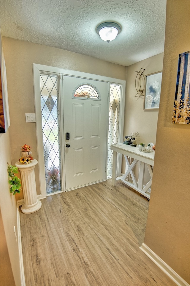 entryway with a healthy amount of sunlight, a textured ceiling, and hardwood / wood-style floors