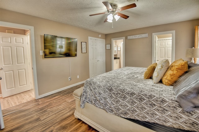 bedroom featuring wood-type flooring, a textured ceiling, connected bathroom, and ceiling fan