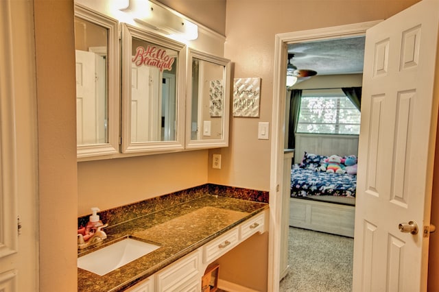 bathroom featuring ceiling fan, vanity, and a textured ceiling