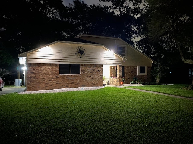 view of front of house with a lawn and central air condition unit