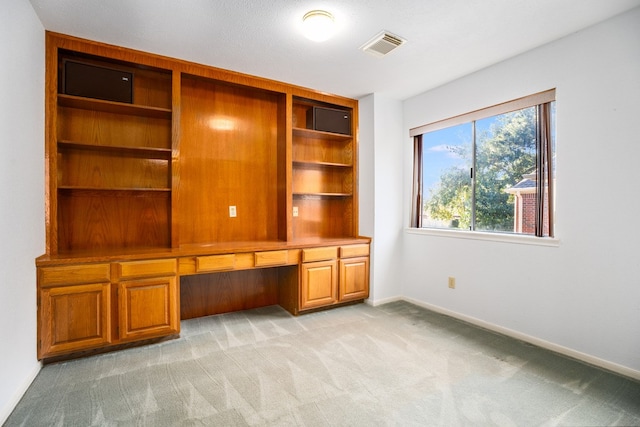 unfurnished office featuring light carpet and built in desk