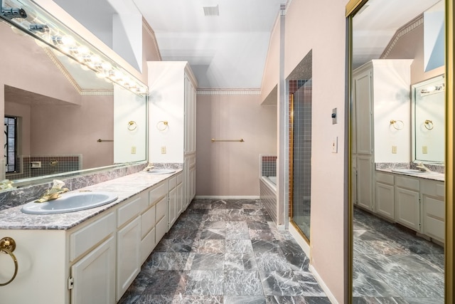 bathroom featuring a washtub, vanity, lofted ceiling, and ornamental molding