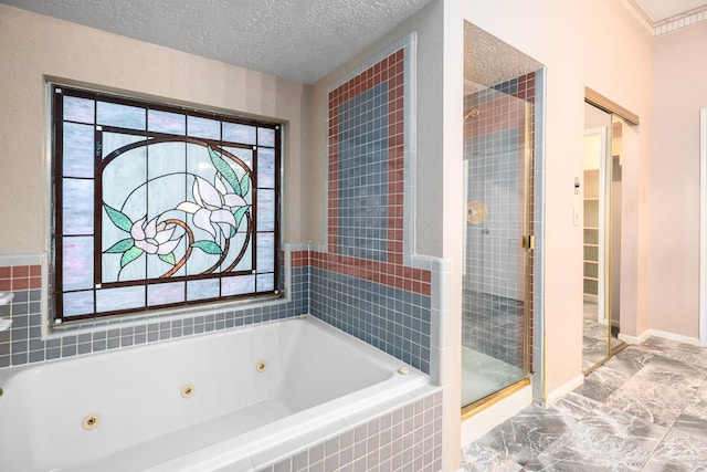 bathroom featuring a textured ceiling and shower with separate bathtub