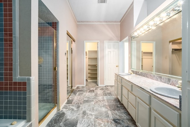 bathroom featuring crown molding, vanity, and tiled shower