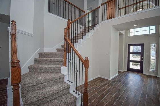 foyer entrance with a towering ceiling and dark hardwood / wood-style floors