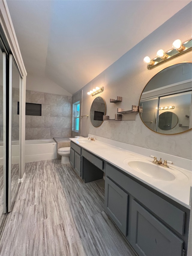 full bathroom with separate shower and tub, hardwood / wood-style floors, toilet, lofted ceiling, and vanity