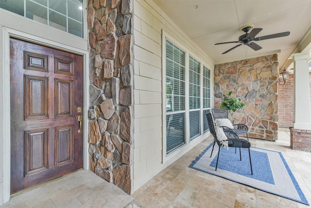 doorway to property featuring ceiling fan and a porch