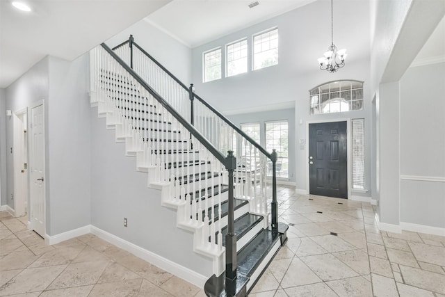 foyer entrance with a chandelier and a high ceiling