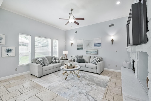 living room featuring ceiling fan, a high end fireplace, and crown molding