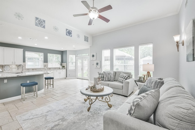 living room featuring ceiling fan, crown molding, and sink