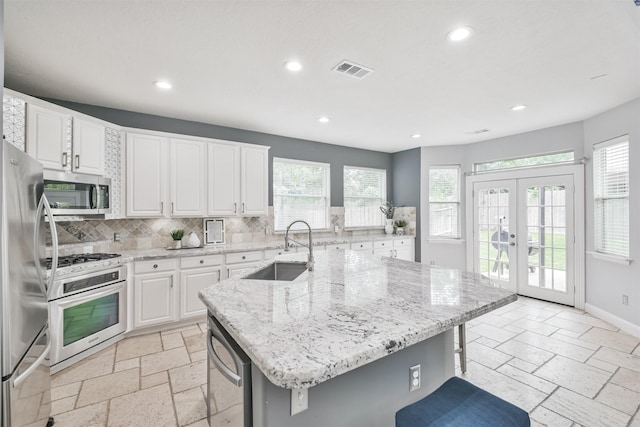 kitchen featuring stainless steel appliances, a breakfast bar, and an island with sink