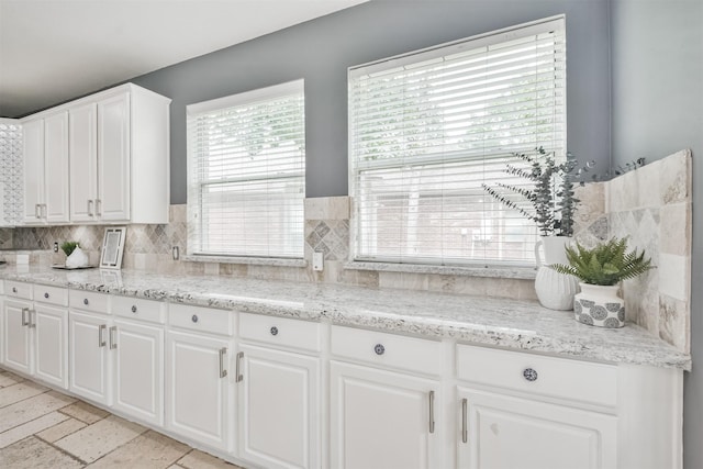 kitchen with white cabinets, tasteful backsplash, and light stone countertops