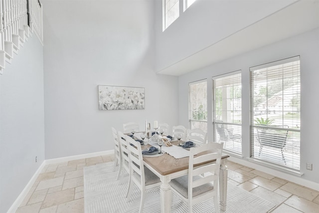 dining area with a wealth of natural light and a towering ceiling