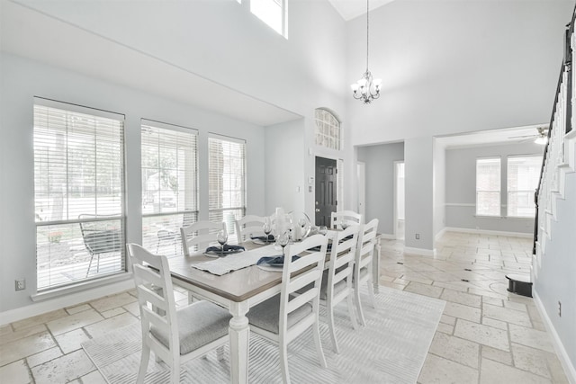 dining area with a high ceiling, plenty of natural light, and a notable chandelier