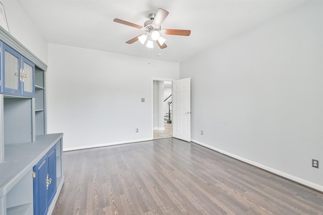 unfurnished living room featuring ceiling fan and dark hardwood / wood-style floors