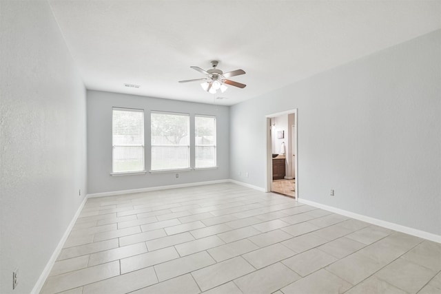 spare room with ceiling fan and light tile patterned floors