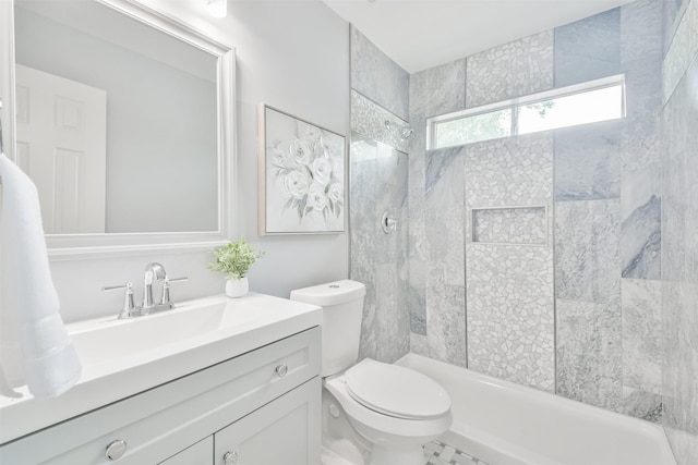 bathroom with toilet, vanity, and a tile shower