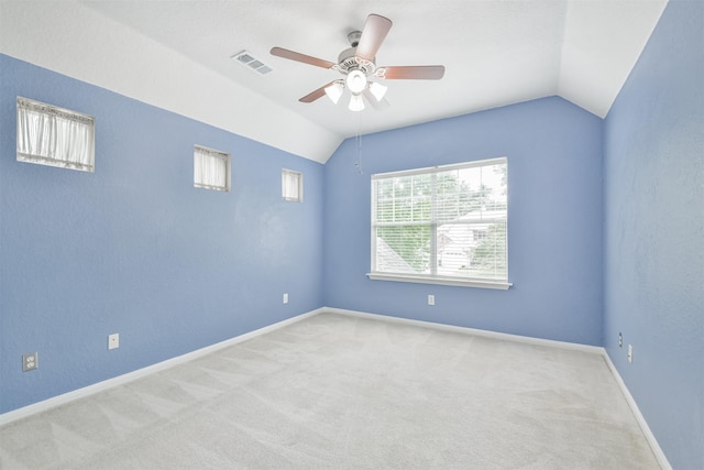 carpeted spare room featuring vaulted ceiling and ceiling fan