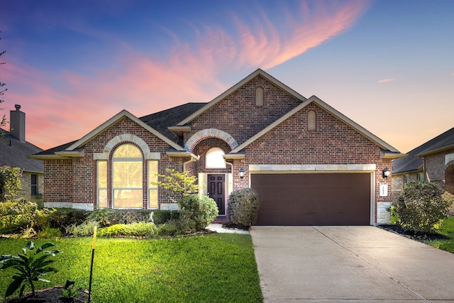 ranch-style home featuring a lawn and a garage