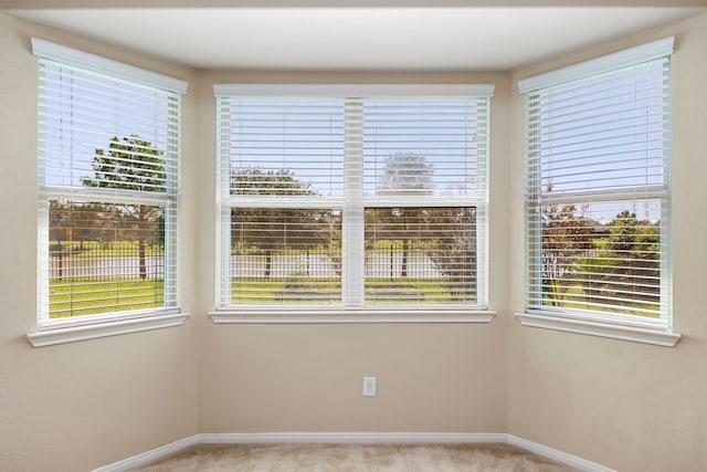 spare room featuring a healthy amount of sunlight and light colored carpet