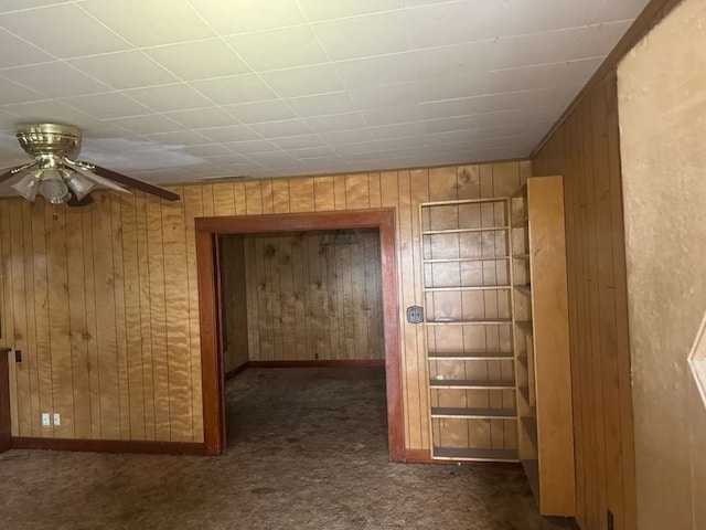 hallway with dark carpet and wooden walls