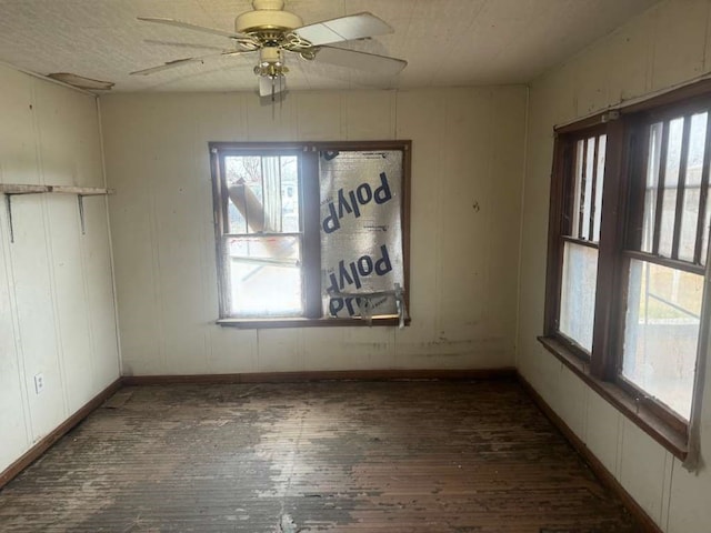 empty room with ceiling fan and dark hardwood / wood-style floors