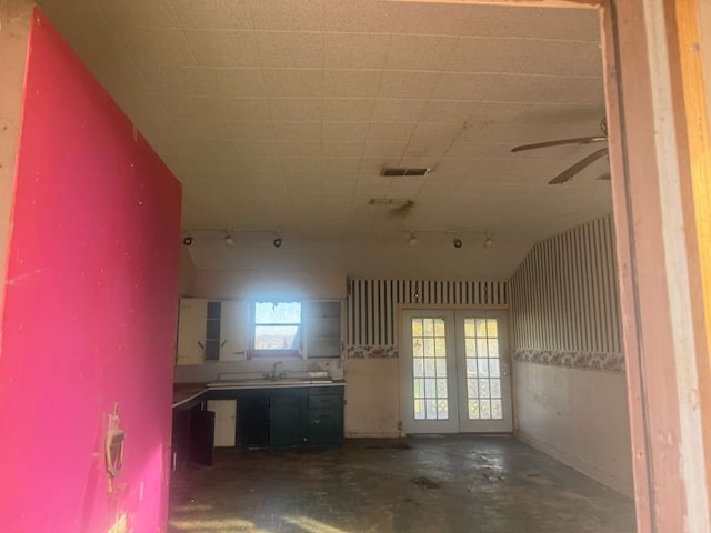 interior space featuring ceiling fan, sink, concrete floors, and vaulted ceiling