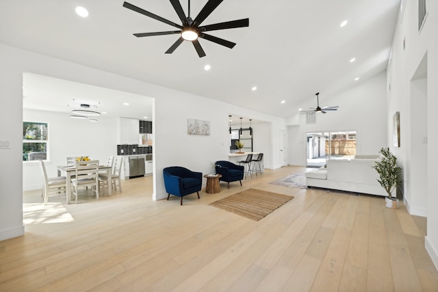 living room featuring high vaulted ceiling, ceiling fan, and light wood-type flooring