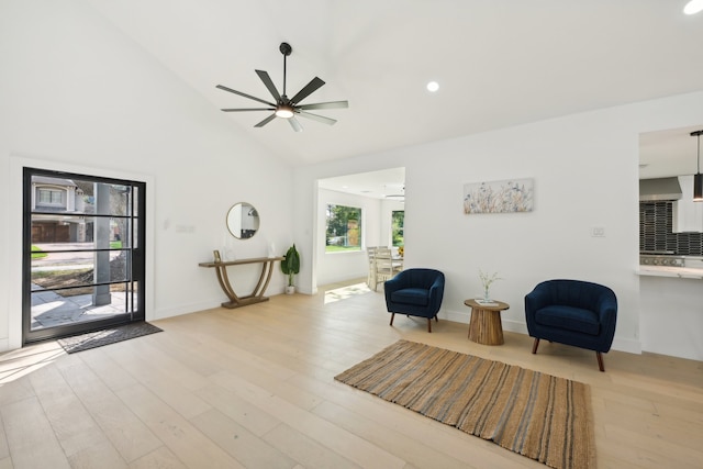 living area with high vaulted ceiling, light hardwood / wood-style flooring, and ceiling fan