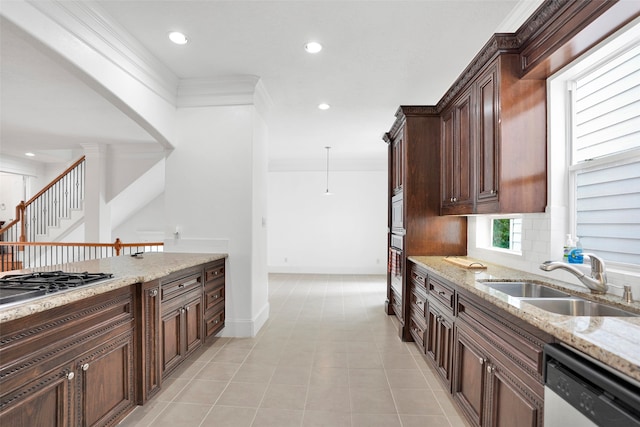 kitchen with white dishwasher, light stone counters, and sink