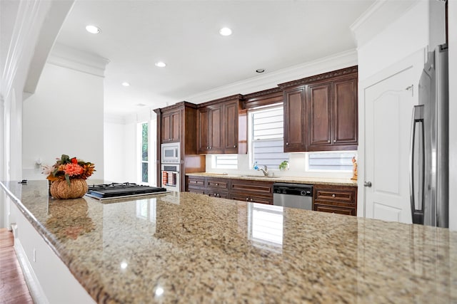 kitchen featuring crown molding, stainless steel appliances, sink, light stone countertops, and hardwood / wood-style flooring