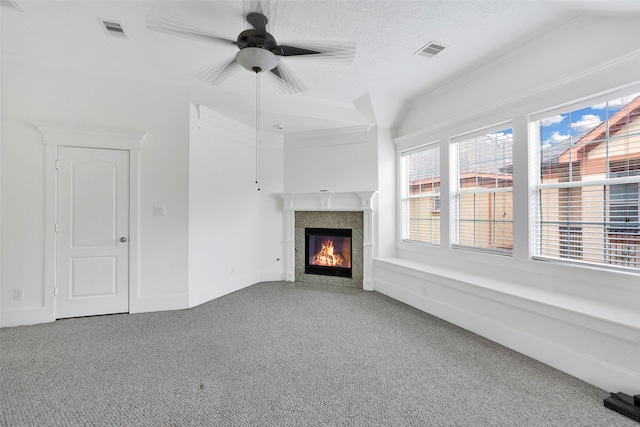 unfurnished living room with ceiling fan, a fireplace, carpet, and ornamental molding