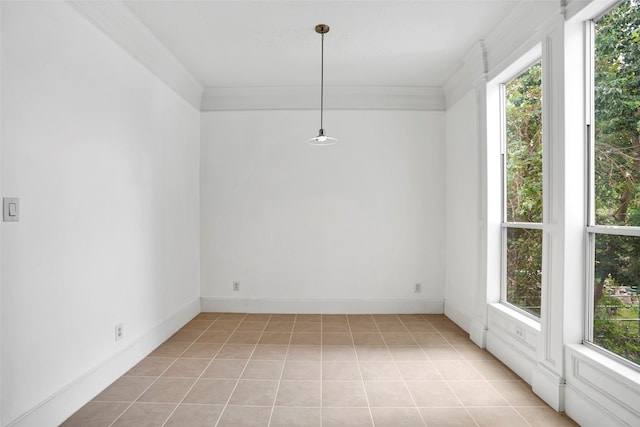 tiled empty room with a healthy amount of sunlight and ornamental molding