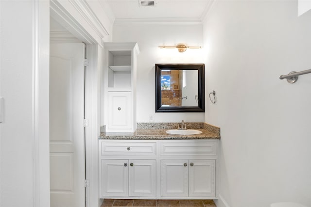 bathroom with ornamental molding and vanity