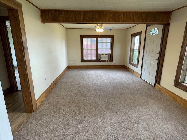 empty room featuring cooling unit, light colored carpet, ceiling fan, and ornamental molding