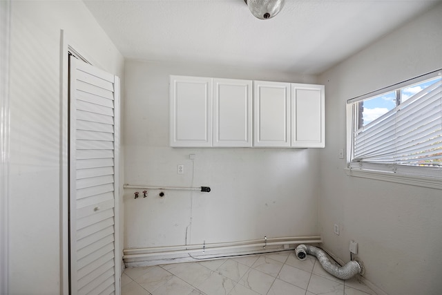 clothes washing area with washer hookup, light tile patterned floors, hookup for an electric dryer, and cabinets